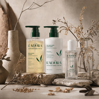 Kadūra CurlDefine Trio for curly hair with shampoo, conditioner and botanical hair perfume oil in an earthy botanical display