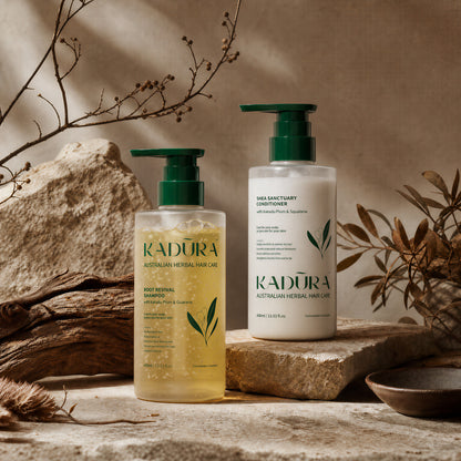 Kadūra SilkFlow shampoo and conditioner duo displayed with botanicals and natural stone